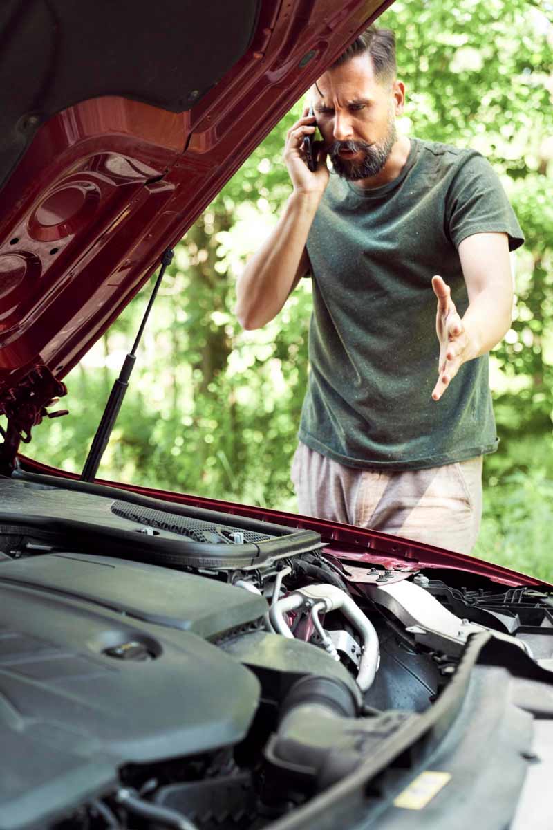 Junger Mann prüft Getriebeschaden bei Schrottauto Ankauf Ratingen